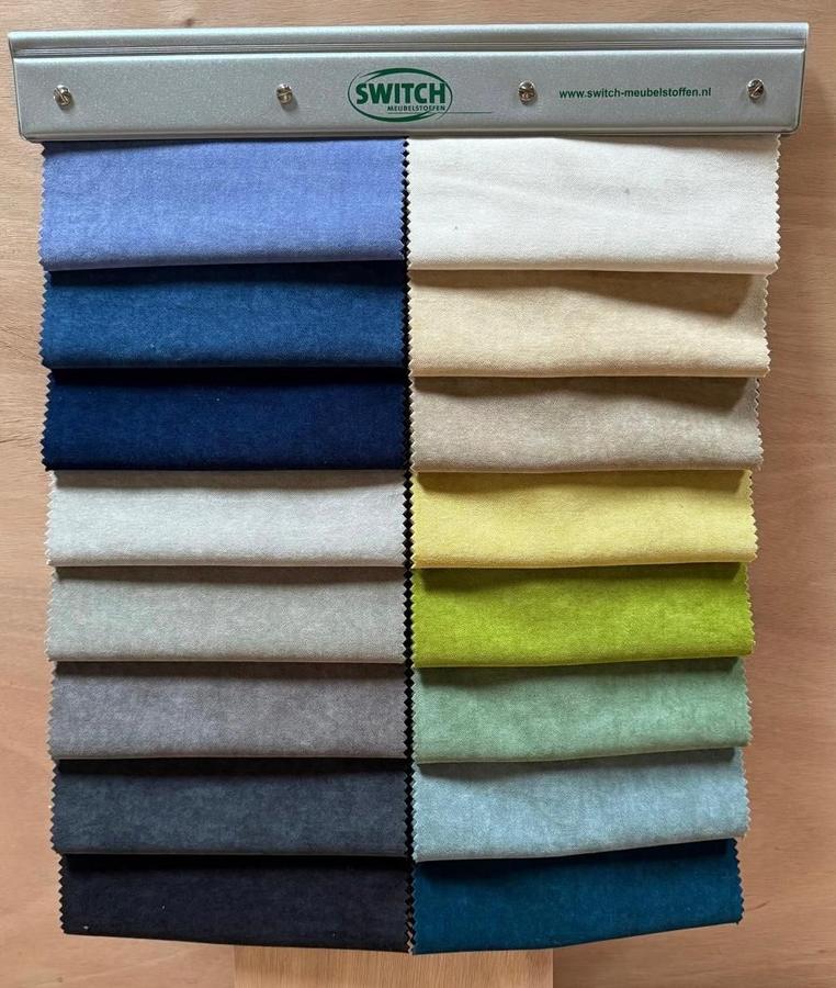 Een stalenboek met meubelstoffen in verschillende kleuren
